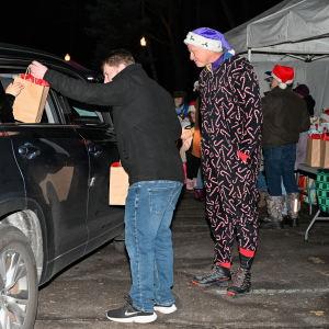 Volunteers pass gifts to Crescent Cove families at this year's holiday drive-thru.