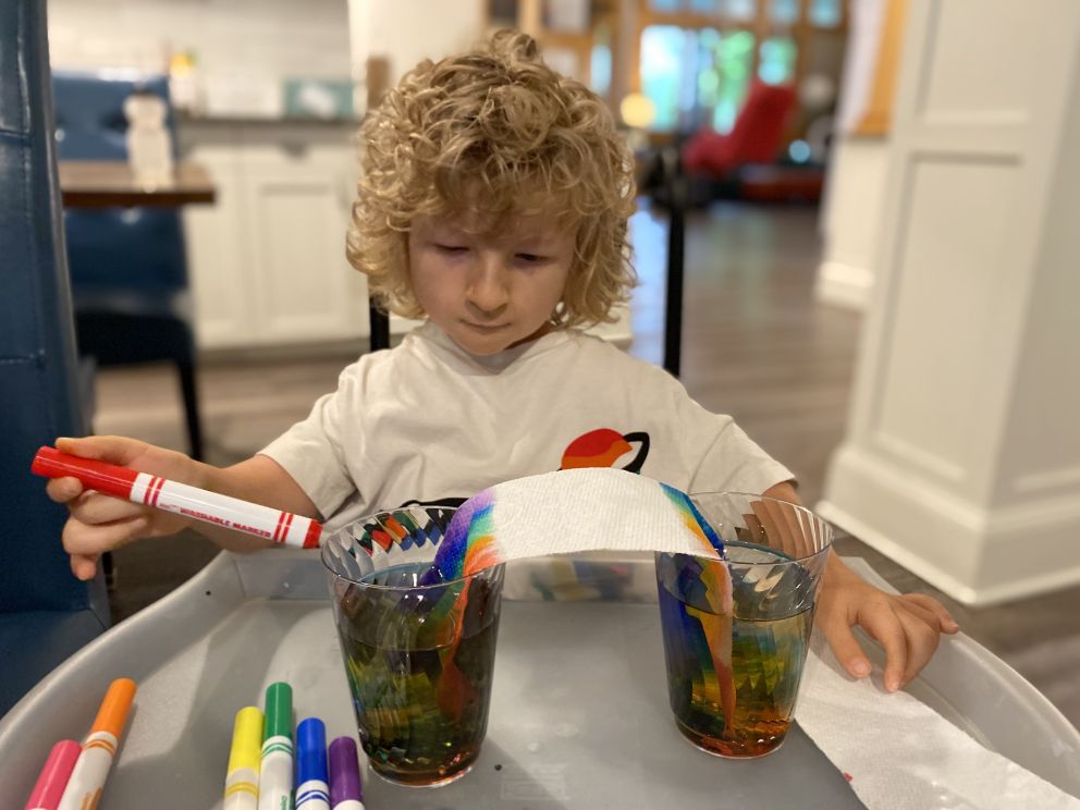 Felix doing an art project using water to make colors blend.